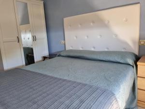 a bedroom with a bed with a blue comforter at Alojamiento Casa Carlota in Villadesuso