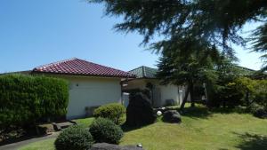 a house with a yard with trees and bushes at Tabi No Yado Harusame in Kumano
