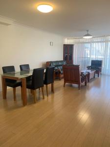 sala de estar con mesa, sillas y sofá en Northpoint Apartments, en Port Macquarie