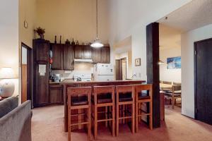 a kitchen with wooden cabinets and a bar with stools at Crestview 70 in Mammoth Lakes