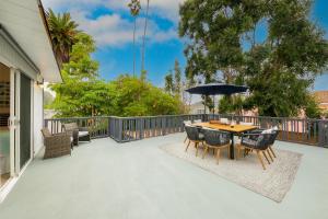 um pátio com uma mesa, cadeiras e um guarda-sol em La Jolla Beach Retreat Compound em San Diego
