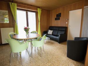 sala de estar con mesa, sillas y sofá en Pleasant Holiday Home in Froidchapelle with Garden en Cerfontaine