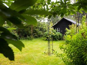 un jardín con un pequeño cobertizo en el fondo en Pleasant Holiday Home in Froidchapelle with Garden en Cerfontaine