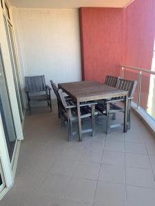 uma mesa de madeira e cadeiras num quarto com uma varanda em Northpoint Apartments em Port Macquarie