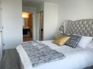 a bed with a black and white comforter and pillows at Downtown 3br/2ba+Views+Skytrain+Free Parking in Vancouver