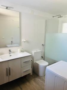 bagno con servizi igienici, lavandino e specchio di Villa Piano Piano a Carovigno