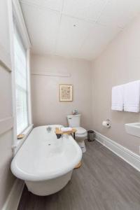 a white bathroom with a tub and a toilet at Renovated 2 bed 2 bath Near Arena and Downtown in Spokane