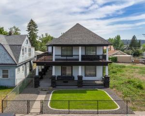 a white house with a porch and a lawn at Renovated 2 bed 2 bath Near Arena and Downtown in Spokane