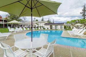uma mesa branca com um guarda-chuva ao lado de uma piscina em Silverado Resort and Spa 271 & 272 em Napa
