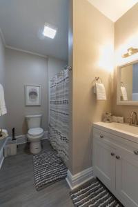 ein Badezimmer mit einem WC, einem Waschbecken und einem Spiegel in der Unterkunft Historic 2 KING BED 1 Bath Near Downtown Spokane in Spokane