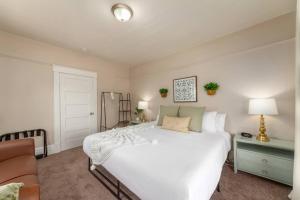 a bedroom with a large white bed and a couch at Historic 2 KING BED 1 Bath Near Downtown Spokane in Spokane