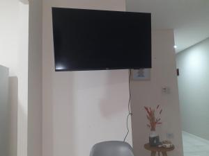 a flat screen tv hanging on a white wall at Departamento temporal Mariano in Santa Rosa