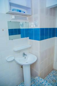 a bathroom with a sink and a mirror at Appartements madame lydie in Pointe-Noire