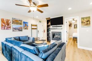 uma sala de estar com sofás azuis e uma ventoinha de tecto em Red Desert Villa em Hurricane