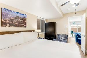 um quarto com uma grande cama branca e uma cadeira em Red Desert Villa em Hurricane