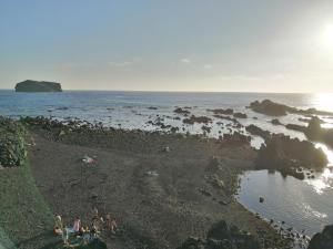 a group of people on a beach near the water at Casa Dos Mosteiros in Mosteiros