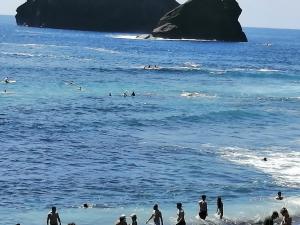 a group of people in the water at the beach at Casa Dos Mosteiros in Mosteiros