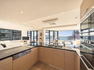 a kitchen with a sink and a living room at Mount Eleven Fabulous Sea Views in Mount Maunganui
