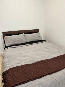 uma cama num quarto com uma parede branca em 2 Bedroom Apartment @ Grenfell Street em Adelaide