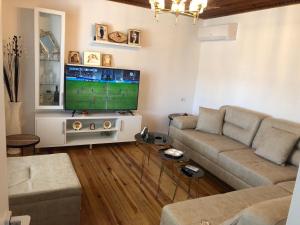 a living room with a couch and a flat screen tv at Villa K & N in Sarandë