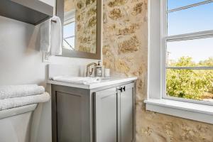 een witte badkamer met een wastafel en een raam bij Fredericksburg Mill in Fredericksburg +45 foto's