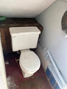 Habitación con baño pequeño con aseo blanco. en Loft DT con mesa de billar en Tijuana