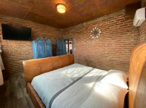 Cama en habitación con pared de ladrillo en Loft DT con mesa de billar en Tijuana