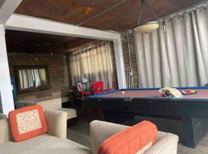 Loft DT con mesa de billar في تيخوانا: غرفة معيشة مع طاولة وكراسي بلياردو
