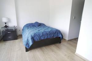 Un dormitorio con una cama con un edredón azul. en Great location, nice apartment Polanco, en Ciudad de México
