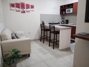 ein Wohnzimmer mit einem Sofa und einer Küche in der Unterkunft Departamento México in Tampico