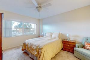 ein Schlafzimmer mit einem Bett, einem Fenster und einem Sofa in der Unterkunft The Blue Heron, Unit 312 in Satellite Beach