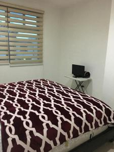 a bedroom with a bed and a laptop on a table at Residencial Sta Lucía -1 in Yelateni