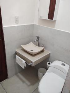 a bathroom with a white toilet and a sink at Departamento México in Tampico