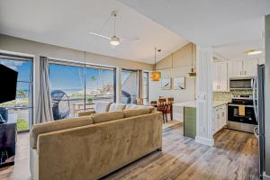 a living room with a couch and a kitchen at Kihei Holiday 311 in Kihei