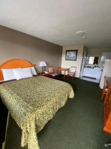 Habitación de hotel con cama, mesa y sillas en Angus Inn Motel en Angus