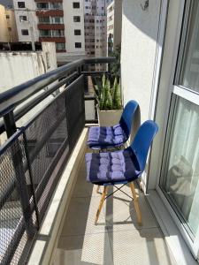 a blue chair sitting on top of a balcony at Sua Casa 48 Prox Av Paulista in Sao Paulo