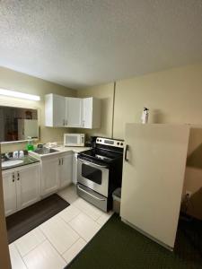 a small kitchen with a stove and a refrigerator at Angus Inn Motel in Angus