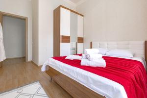 1 dormitorio con 1 cama grande con manta roja y almohadas blancas en Expo Residentce Кабанбай Батыра 60А, 