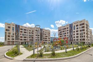 un parque infantil frente a dos grandes edificios en Expo Residentce Кабанбай Батыра 60А, 
