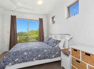 a bedroom with a bed and a window at Beach Bliss Luxurious Apartment with Pool in Kingscliff