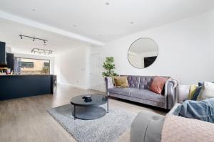 a living room with a couch and a table at Urban Luxury 4-Bed Retreat Explore And Relax in London