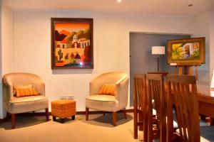 sala de estar con 2 sillas y mesa en Hotel Astur en Salta