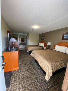 um quarto de hotel com duas camas e uma televisão de ecrã plano em Angus Inn Motel em Angus