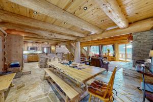 a dining room with a wooden table and a kitchen at Lakeside Lodge in Donnelly
