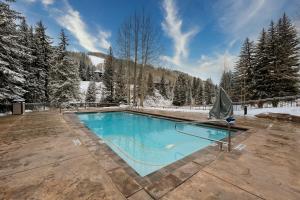 una piscina en la nieve en una terraza de madera en Lion Square Lodge South 255, 257 & 261, en Vail