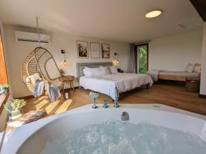 a bathroom with a tub and a bedroom with a bed at Ski in Tremblant and Mont Blanc, Views, Spa and Pool table in Saint-Faustin