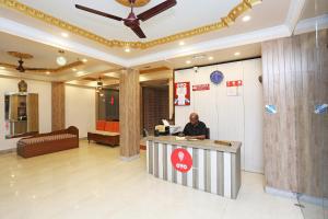 a man sitting at a counter in a lobby at OYO Flagship Sushama Newtown in Thākurdwari