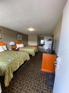 a hotel room with two beds and a flat screen tv at Angus Inn Motel in Angus