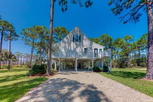 a house with a wrap around porch with trees at Sea-Ya on Joe's Pass in Indian Pass