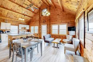 MontgomeryにあるModern Log Chalet - Upper Levelのテーブルと椅子のあるキッチンとダイニングルーム